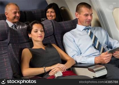 Airplane passengers relax during flight cabin sleep businesspeople