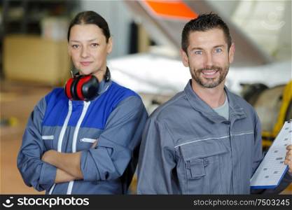 airplane service crew repairing plane in hangar