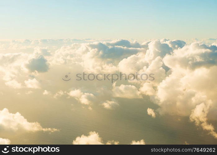 Airplane view of beautiful landscape with blue sky, gold colored clouds and ocean at sunny day