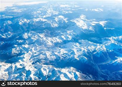 Airplane view of blue mountains covered with white snow. Can be used as nature background