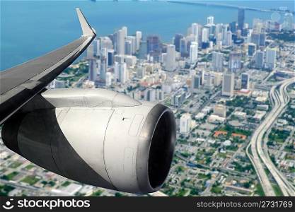 airplane wing aircraft turbine flying on Miami downtown