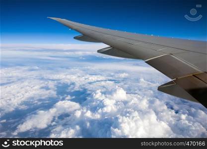 airplane wing with blue skies and clouds