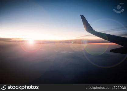Airplane wings in the sky and a mountains view scene in the sunrise. Travel and adventure.. Airplane wings in the sky and a mountains view scene in the sunr