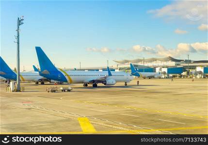 Airplanes at runway by Boryspil airport terminal in evening sunshine, Kyiv, Ukraine