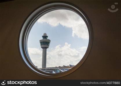Airport command tower seen throug a window of the terminal