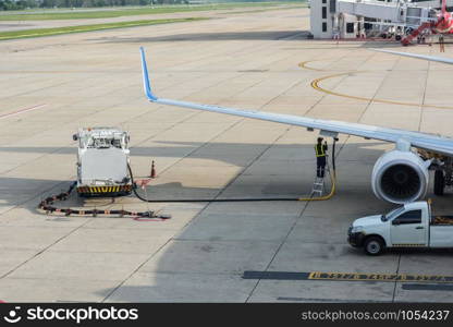 Airport man worker service refuelling the aircraft, runway