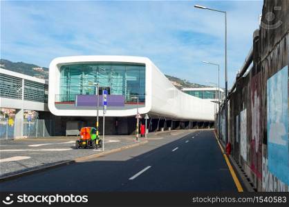 Airport terminal building of modern architecture, passage, electromobile and asphalt entry road, Funchal, Madeira island, Portugal