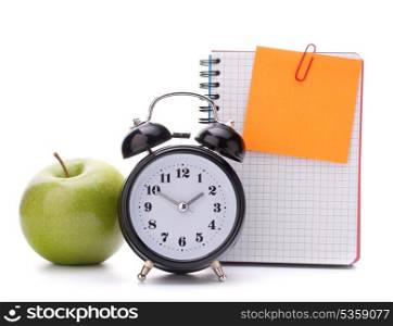 Alarm clock, blank notebook sheet and apple. Schoolchild and student studies accessories. Back to school concept.