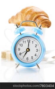 Alarm clock, coffee and croissant on white