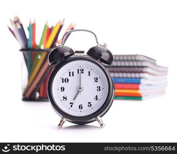 Alarm clock, notebook stack and pencils. Schoolchild and student studies accessories. Back to school concept.