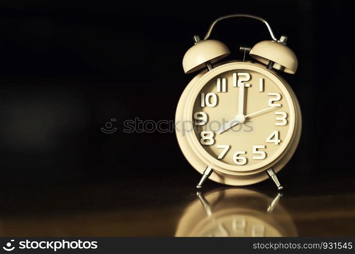 Alarm clock on table with black background and free space for text.
