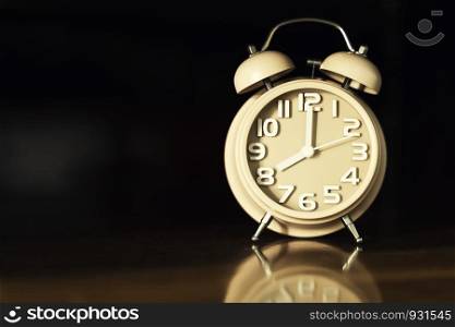 Alarm clock on table with black background and free space for text.