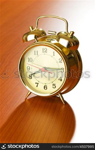 Alarm clock on the wooden table
