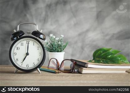 Alarm clock on wood table with school supplies , back to school concept