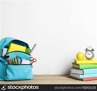 alarm clock stack books well packed school bag with supplies