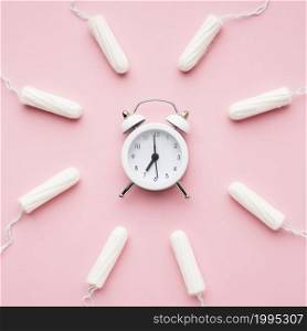 alarm clock surrounded by tampons