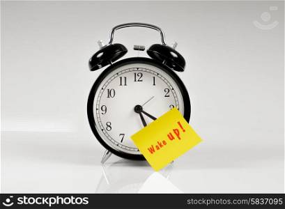 Alarm clock with a yellow note saying wake up