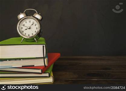 alarm clock with books pile desk
