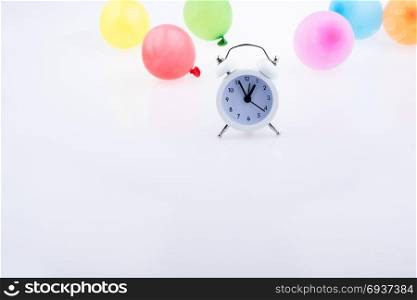 Alarm clock with color balloons on the white background
