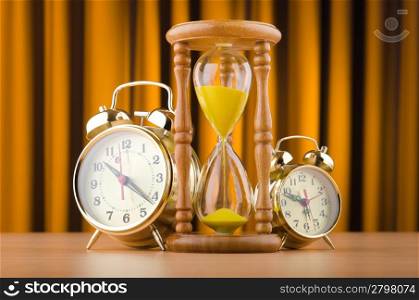 Alarm clocks and hourglass in time concept