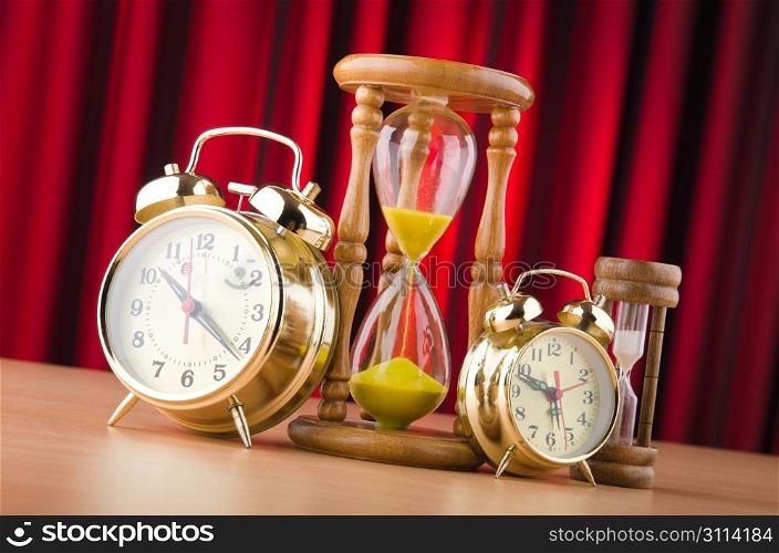 Alarm clocks and hourglass in time concept
