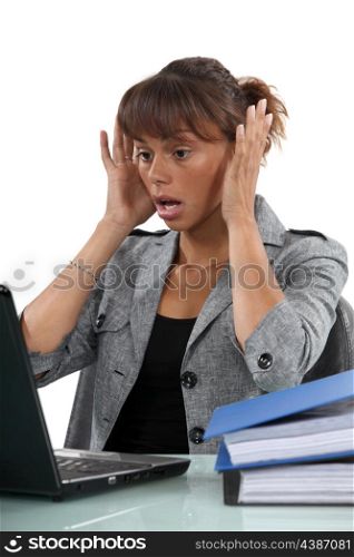 Alarmed woman looking at her laptop