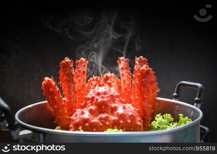 Alaskan King Crab Cooked steamer food on steaming pot seafood and lettuce vegetable with dark background / red crab hokkaido