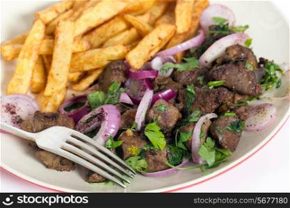 Albanian Liver, a traditional Turkish spiced lamb&rsquo;s liver recipe popular throughout the Middle East, with french fried potato chips and a fork.