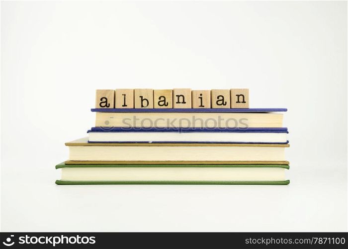 albanian word on wood stamps stack on books, language and conversation concept