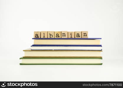 albanian word on wood stamps stack on books, language and conversation concept