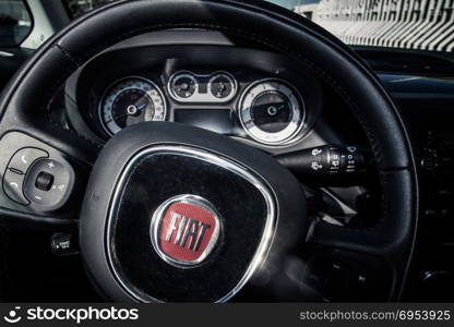 Alberobello, Italy - August 2, 2014: Close up of steering wheel and dashboard inside of a private car model Fiat 500L.