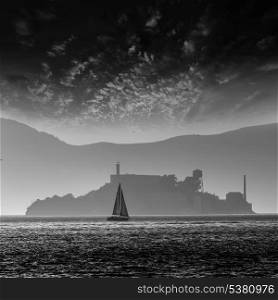 Alcatraz island penitentiary at sunset backlight sailboat in san Francisco California USA