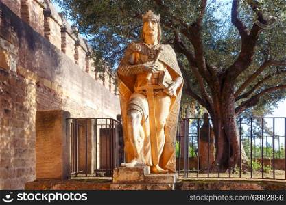 Alcazar de los Reyes Cristianos in Cordoba, Spain. Stone statue of a medieval knight king in Alcazar de los Reyes Cristianos or Castle of the Christian Monarchs in the sunny day, Cordoba, Andalusia, Spain