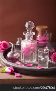alchemy and aromatherapy set with rose flowers and flasks