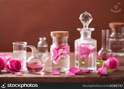 alchemy and aromatherapy set with rose flowers and flasks