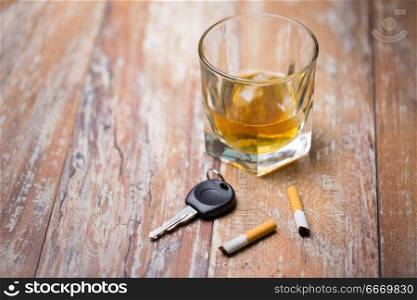 alcohol abuse, drunk driving and people concept - close up of whiskey glass and car key on table. close up of alcohol and car key on table. close up of alcohol and car key on table