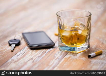 alcohol abuse, drunk driving and people concept - close up of whiskey glass and car key on table. close up of alcohol and car key on table. close up of alcohol and car key on table