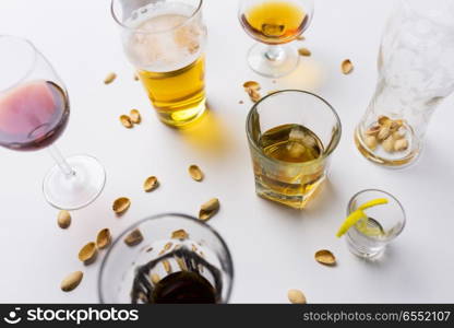 alcohol addiction and drunkenness concept - glasses of different drinks on messy table. glasses of different alcohol drinks on messy table. glasses of different alcohol drinks on messy table