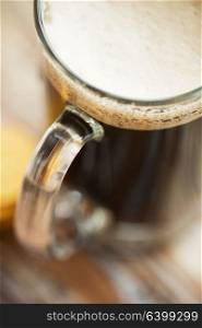 alcohol and drinks concept - close up of dark draft beer glass mug. close up of dark draft beer glass mug