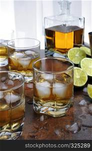 Alcohol cocktail with brandy, whiskey or rum, lime and ice in glasses