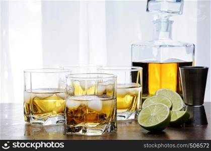 Alcohol cocktail with brandy, whiskey or rum, lime and ice in glasses