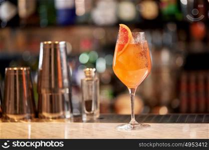 alcohol drinks and luxury concept - glass of grapefruit cocktail at bar. glass of grapefruit cocktail at bar