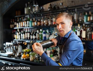 alcohol drinks, people and luxury concept - barman with shaker preparing cocktail at bar. barman with shaker preparing cocktail at bar. barman with shaker preparing cocktail at bar