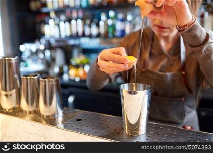 alcohol drinks, people and luxury concept - woman bartender with shaker braking egg and preparing cocktail at bar. bartender with shaker preparing cocktail at bar