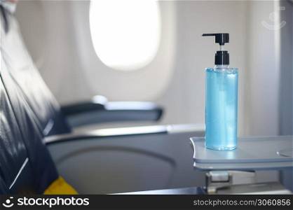 alcohol gel sanitizer is on tray table in the aircraft for passengers during flight