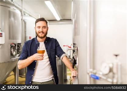 alcohol production, manufacture, business and people concept - man drinking and testing craft beer at brewery. man drinking and testing craft beer at brewery. man drinking and testing craft beer at brewery