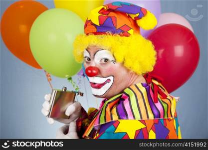 Alcoholic clown sneaks a drink from his flask.