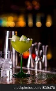 Alcoholic cocktail of green color on a bar counter. Cucumber cocktail.