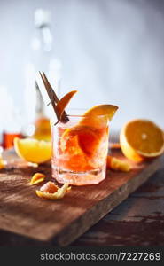Alcoholic cocktail with orange peel and ice.