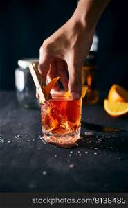 Alcoholic cocktail with orange peel and ice. 